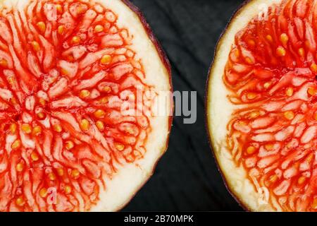 Les figues sont mûres. Gros plan de fruits de figuier tranchés sous forme de texture inscrite dans un rectangle sur fond de texture noire Banque D'Images