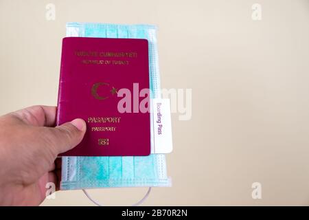 Homme main détenir passeport et masque médical de protection.Tourist manipuler un passeport et un masque médical. Concept l'impact négatif du coronavirus sur le monde Banque D'Images