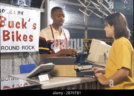 Round Rock, Texas Etats-Unis: Une jeune fille de 13 ans qui retourne un casque de vélo pour le magasin où un jeune employé de Black l'aide. M. ©Bob Daemmrich Banque D'Images