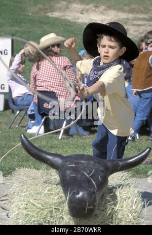 Austin, Texas, États-Unis : un garçon de cinq ans lance un lasso à la tête de la barre en bois à la maternelle « rodéo » de son école. ©Bob Daemmrich Banque D'Images