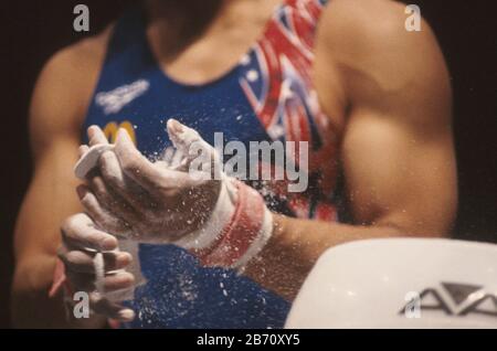 États-Unis gymnastique. Le concurrent met de la craie sur ses mains en préparation à l'épreuve de cheval de pommel pour hommes. ©Bob Daemmrich Banque D'Images