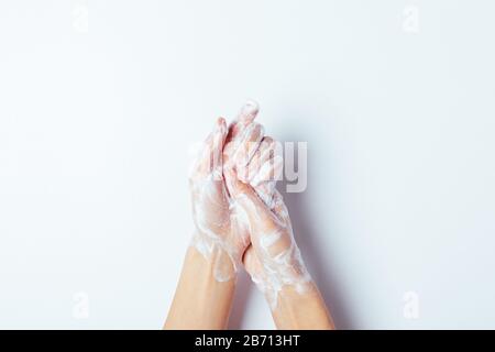 Femme se lavant soigneusement les mains avec du savon, gros plan sur fond blanc, vue de dessus. Banque D'Images