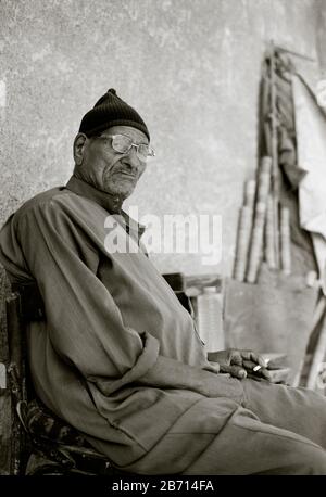 Photographie de voyage en noir et blanc - l'homme égyptien dans la ville des morts au Caire en Egypte en Afrique du Nord Moyen-Orient Banque D'Images