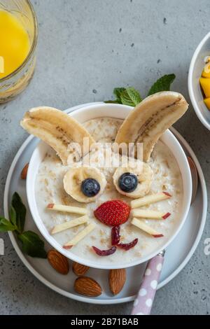 Bols drôles avec porridge avec bunny, chick et fleurs pour Pâques Banque D'Images