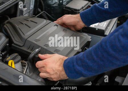 Gros plan du moteur de contrôle des mains mécaniques sous le capot dans la voiture cassée. Réparation du concept du véhicule. Service automobile Banque D'Images