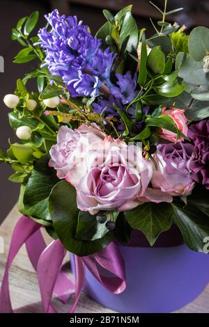 Joli bouquet de bouquets avec rose rose et hyacinthes en boîte violette, photo verticale. Utile pour les cartes de vœux, les modèles instagram et Print Banque D'Images