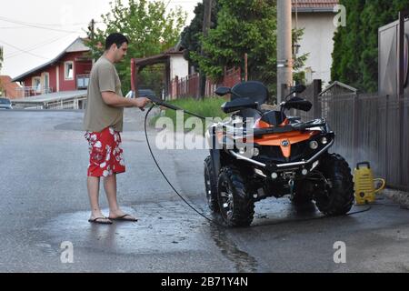 Laver un quad avec un fusil de lavage de voiture Banque D'Images