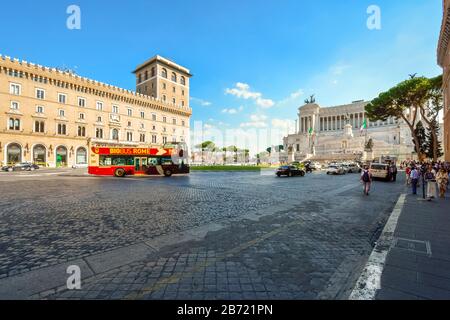 Un tour-bus traverse la Piazza Venezia avec le monument Vittorio Emanuele en vue dans la ville historique de Rome, Italie. Banque D'Images