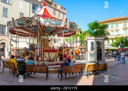Un petit manège coloré se visite dans le centre historique de la ville méditerranéenne de Menton, en France, sur la Côte d'Azur. Banque D'Images
