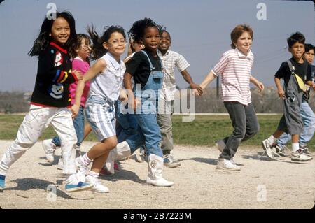 Austin Texas USA: Groupe multiracial d'enfants sur le terrain de jeu à l'école primaire. ©Bob Daemmrich Banque D'Images