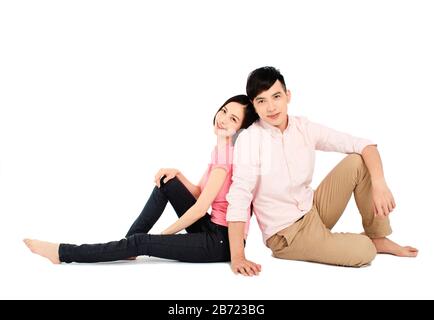 jeune couple asiatique assis sur le sol isolé sur fond blanc Banque D'Images