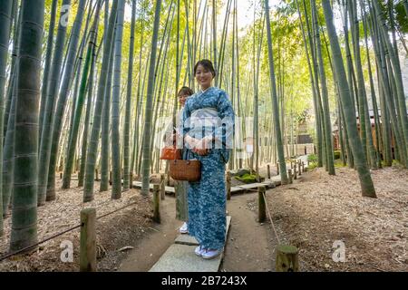 Deux femmes touristes dans les kimono traditionnels explorent la forêt de bambou derrière le temple Hokokuji, Kamakura, Kanagawa, Japon. Banque D'Images