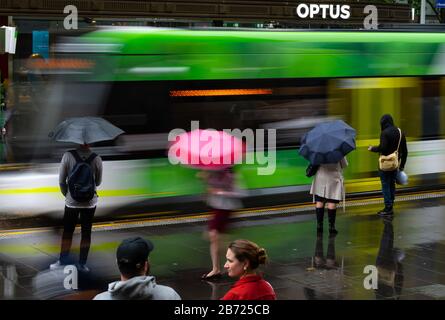 Les navetteurs attendent un tramway dans la rue Bourke, Melbourne, Victoria, Australie. Banque D'Images