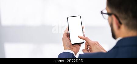 Gros Plan Sur Les Mains De La Personne Tenant Le Téléphone Mobile Avec Un Écran Vide Au Bureau Banque D'Images