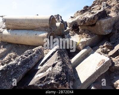 Masse pile de débris de démolition de route, ruble de route comprenant des tuyaux d'égout en béton cassés, vue rapprochée moyenne sur l'asphalte et les bordures en béton, vue n° 1 Banque D'Images