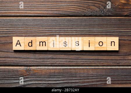 ADMISSION mot écrit sur une cale en bois. Texte sur l'admission de votre table en bois, design concept. Banque D'Images