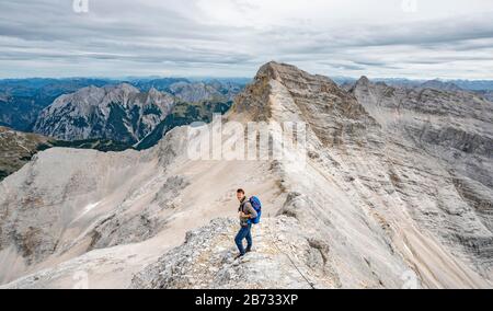 Mountaineer sur la crête de l'Oedkarspitzen, vue sur le pic de Birkkarspitze, chaîne de Hinterautal-Vomper, Karwendel, Tyrol, Autriche Banque D'Images