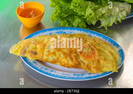 Plaque de crêpe vietnamienne Banh Xeo servie avec des légumes Banque D'Images