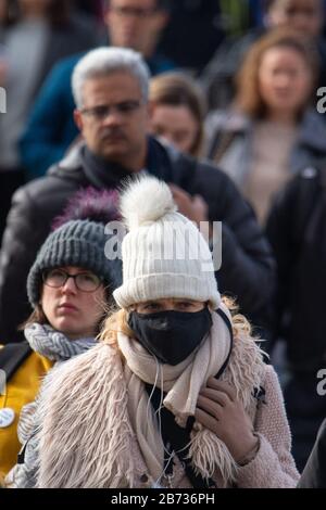 Une femme portant un masque protecteur alors que les navetteurs traversent le pont de Londres pendant l'heure de pointe du matin à Londres , comme l'a averti le plus haut scientifique du gouvernement que jusqu'à 10 000 personnes au Royaume-Uni sont déjà infectées. Banque D'Images