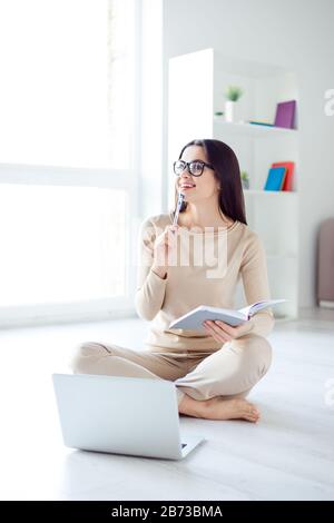 Concept Freelance. Jeune femme réussie travaillant à la maison tout en étant assis à l'étage avec ordinateur portable et a une nouvelle idée. Banque D'Images