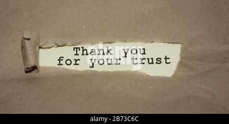 Merci pour vos mots de confiance apparaissant sous du papier brun déchiré, merci concept Banque D'Images