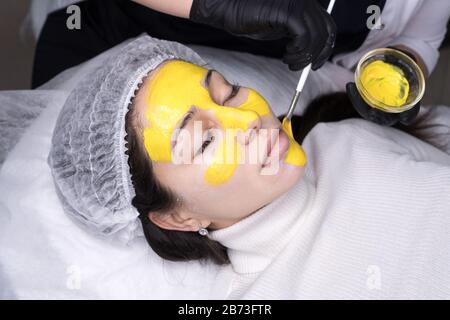 Soin de peau de brosse faciale rétinol. Procédure de décollement de la femme. Cosmologie thérapie jeune fille. Acide hyaluronique. Concept de beauté. Banque D'Images