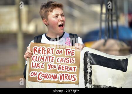 Un manifestant est titulaire d'un panneau référençant le coronavirus lors d'une grève du climat scolaire qui s'est tenue de l'Hôtel de ville de Cardiff à l'Assemblée nationale du Pays de Galles. Banque D'Images