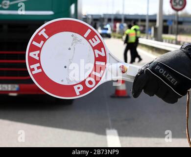 13 mars 2020, Rhénanie-Palatinat, Lauterbourg : un policier arrête un camion avec sa truelle rouge. À la frontière germano-française, des contrôles aux frontières resserrés ont lieu au passage frontalier de Lauterbourg à l'entrée de l'Allemagne. Photo: Uli Deck/Dpa Banque D'Images