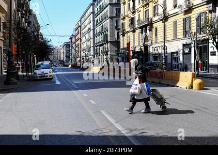 Naples, Italie. 13 mars 2020. Les personnes portant des masques de protection marchent dans le centre de la ville de Naples, après un décret du gouvernement déclarant à toute l'Italie une zone protégée pour lutter contre l'infection du coronavirus covid-19. Crédit: Independent Photo Agency Srl/Alay Live News Banque D'Images