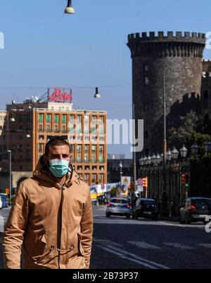 Naples, Italie. 13 mars 2020. Les personnes portant des masques de protection marchent dans le centre de la ville de Naples, après un décret du gouvernement déclarant à toute l'Italie une zone protégée pour lutter contre l'infection du coronavirus covid-19. Crédit: Independent Photo Agency Srl/Alay Live News Banque D'Images