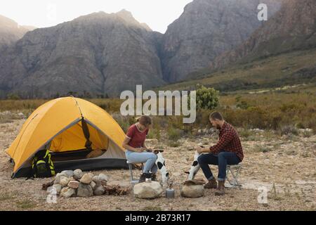 Vue latérale du couple avec deux chiens à l'extérieur Banque D'Images