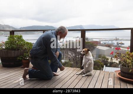 Homme senior appréciant sa terrasse avec son chien Banque D'Images