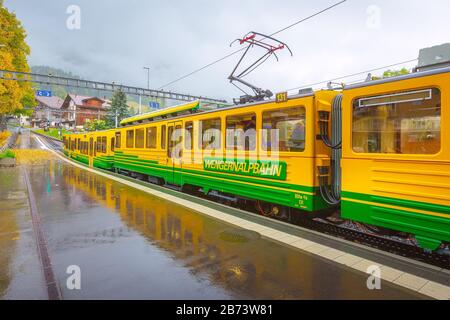 Wengen, Suisse - 10 octobre 2019 : le vert et le train jaune de la Wengernalpbahn de Lauterbrunnen à Kleine Scheidegg arrivant de la stati Banque D'Images