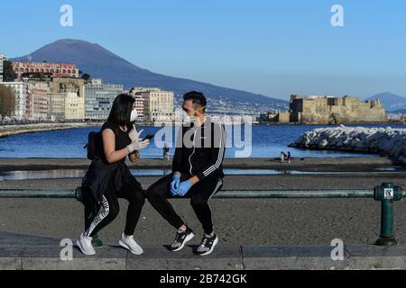 Naples, Italie. 13 mars 2020. Les gars portant des masques de protection, dans le fond du front de mer de Naples, après un décret gouvernemental déclarant à toute l'Italie une zone protégée pour lutter contre l'infection du coronavirus covid-19. Crédit: Independent Photo Agency Srl/Alay Live News Banque D'Images