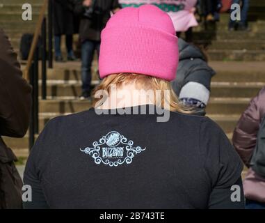 Arrière de la jeune femme avec des cheveux blonds portant un chapeau rose et une chemise noire. Banque D'Images