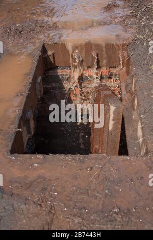 Grille anti-tempête cassée. De l'eau sale et des ordures entrent dans la gouttière. Banque D'Images