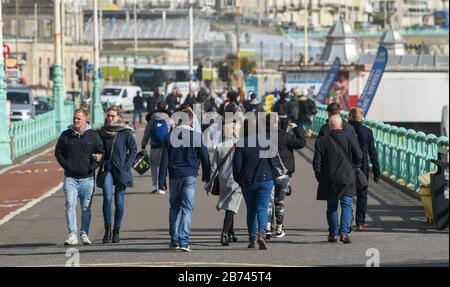 Brighton Royaume-Uni 13 mars 2020 - Brighton est toujours occupé malgré l'épidémie de Coronavirus alors que les visiteurs profitent d'une promenade sur le front de mer sous un beau soleil aujourd'hui. Crédit: Simon Dack / Alay Live News Banque D'Images