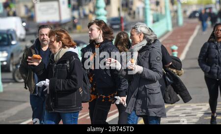 Brighton Royaume-Uni 13 mars 2020 - Brighton est toujours occupé malgré l'épidémie de Coronavirus alors que les visiteurs profitent d'une promenade sur le front de mer sous un beau soleil aujourd'hui. Crédit: Simon Dack / Alay Live News Banque D'Images