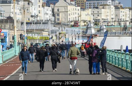 Brighton Royaume-Uni 13 mars 2020 - Brighton est toujours occupé malgré l'épidémie de Coronavirus alors que les visiteurs profitent d'une promenade sur le front de mer sous un beau soleil aujourd'hui. Crédit: Simon Dack / Alay Live News Banque D'Images