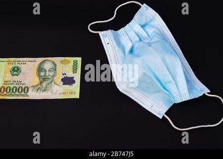 L'argent au Vietnam Dong, VND masque vietnamien de protection de santé visage contour d'oreille chirurgical pour le médecin, les gens Prennent soin de la santé et de protéger la maladie du coronavirus COVI Banque D'Images