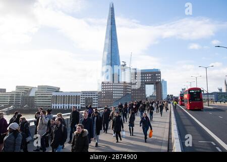 Vue générale des personnes qui traversent le London Bridge, dans le centre de Londres, pendant l'heure de pointe du matin, comme l'a prévenu le plus grand scientifique du gouvernement que jusqu'à 10 000 personnes au Royaume-Uni sont déjà infectées par le Covid-19. Banque D'Images