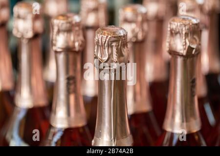 Gros plan de bouteilles de vin mousseux / champagne scellées, remplies d'un liquide alcoolique rouge. Concept pour la fête, la célébration, l'anniversaire ou d'autres événements. Banque D'Images