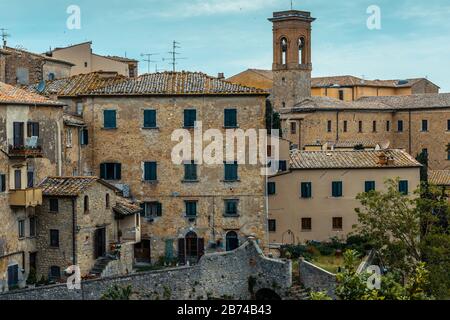 Vieille ville historique de Volterra, Toscane, Italie, avec des bâtiments résidentiels et un clocher d'église vu de la Piazza XX Settemembre un après-midi de mai. Banque D'Images