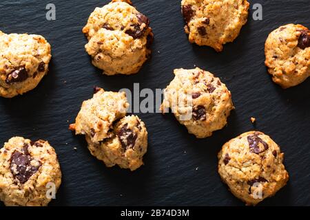 Concept de nourriture saine Sentier fait maison Mélangez des grains entiers bio l'énergie et des biscuits au chocolat sur fond de pierre d'ardoise noire avec espace de copie Banque D'Images