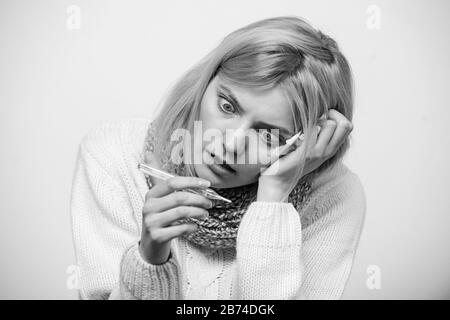 Mesurer la température. La fièvre de la pause des recours. La prise de température et d'évaluer les symptômes. Concept à haute température. Femme se sent gravement malade l'éternuement. Fille en tissu écharpe tenir thermomètre et close up. Banque D'Images