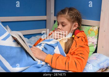 Une fille malade tousse posée au lit Banque D'Images