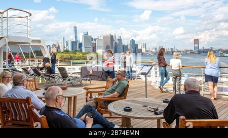 Une ville dans la ville. Traversez l'océan Atlantique de Brooklyn à Southampton à bord du paquebot Queen Mary 2. Avec une capacité de près de 2 700 passagers et un équipage de plus de 1250 passagers, la Reine Mary est une petite ville de sa propre. Ici, les passagers prennent la vue de Manhattan et de Brooklyn avant de débarquer de New York. Banque D'Images