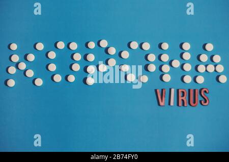 Texte virus Corona en lettres ukrainiennes de comprimés blancs et de lettres en bois sur fond bleu. Nouveau concept d'éclosion de coronavirus. inf. Virus 2019-nCoV Banque D'Images