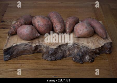 Pommes de terre crues douces sur une planche à découper Banque D'Images