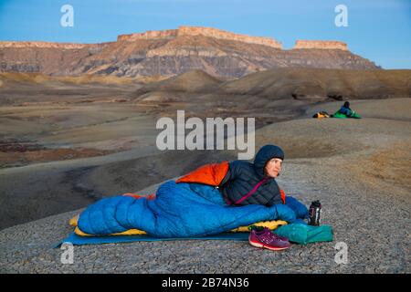 Mylène Jacquemart et Robert Hahn regardent le lever du soleil depuis le camp dans les badlands de la zone de loisirs Factory Butte près de Caineville, Utah. North Caineville Mes Banque D'Images